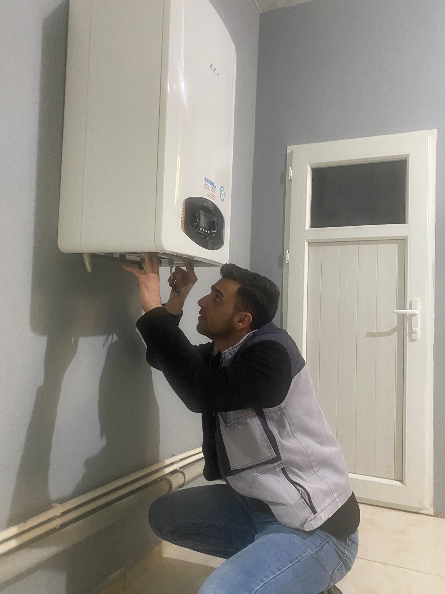 Kombi üzerinde çalışan teknisyen